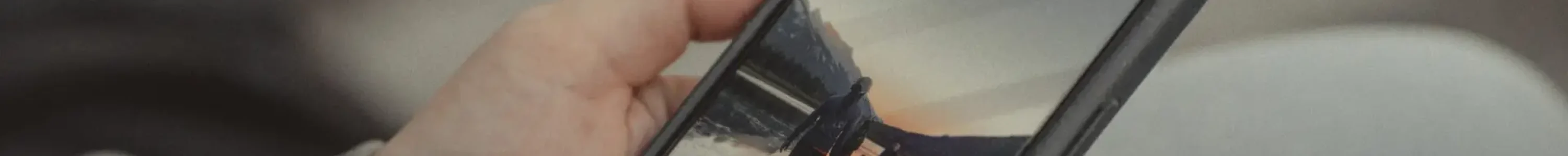 Close-up of hands holding a smartphone showing a mountain scene, captured outdoors in Banff.
